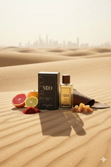Luxury perfume bottle and box with citrus fruits, spices, and incense on Dubai desert sand.