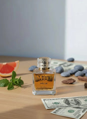 Luxury perfume bottle with mint, grapefruit, stones, and dollar bills on a wooden table