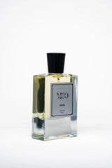 Clear glass bottle of DHINA perfume with black cap on white background, 60ml size