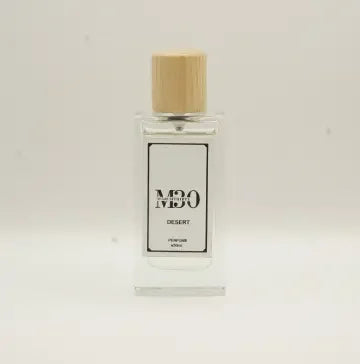 Clear glass perfume bottle with wooden cap labeled 'Desert' against light background