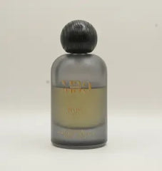Luxury perfume bottle with gold text, frosted glass, and black round cap on light background